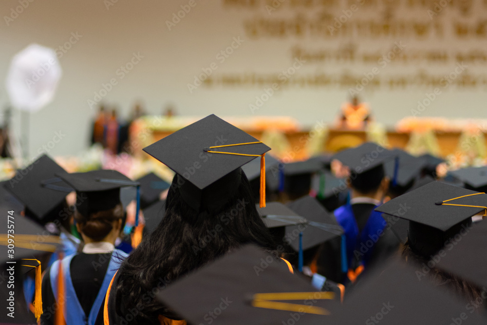 Rear view and soft selective focus of the graduates in the graduation commencement ceremony recieving diploma degree certificate. Rear view and soft selective focus of the graduates in the graduation commencement ceremony recieving diploma degree certificate.