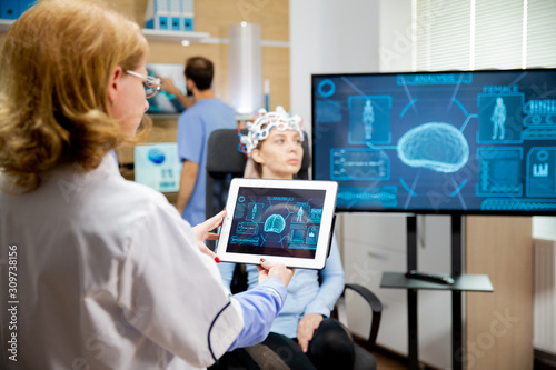 Doctor tracking the evolution of the patient's brain on the tablet photo