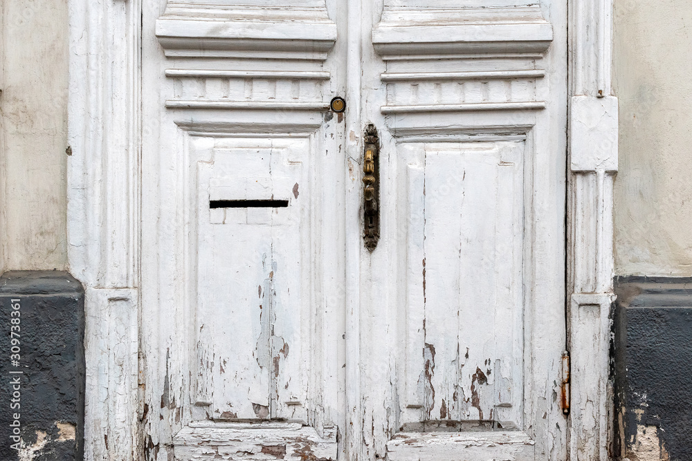 A fragment of an old wooden door with peeling paint. Selective focus.