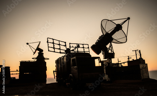 Satellite dishes or radio antennas against evening sky. Selective focus