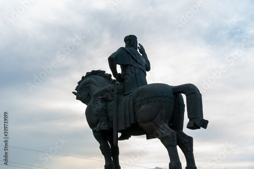 Tbilisi, Georgia, JULY, 2019: Stone equestrian statue rider with sword and raised hand on the river Bank