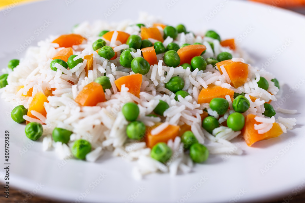 Basmati rice with carrots and green peas. Close up view.