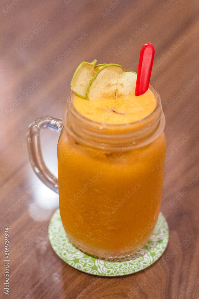fruit juice mixture of Carrot, Apple and Ginger served in a tall glass fruit juice mixture of Carrot, Apple and Ginger served in a tall glass