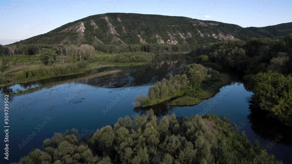 The remain of the reef of the ancient sea, composed of limestone - shikhan Kushtau on a summer day. The main river of Bashkiria - Belaya. Aerial view. The remain of the reef of the ancient sea, composed of limestone - shikhan Kushtau on a summer day. The main river of Bashkiria - Belaya. Aerial view.