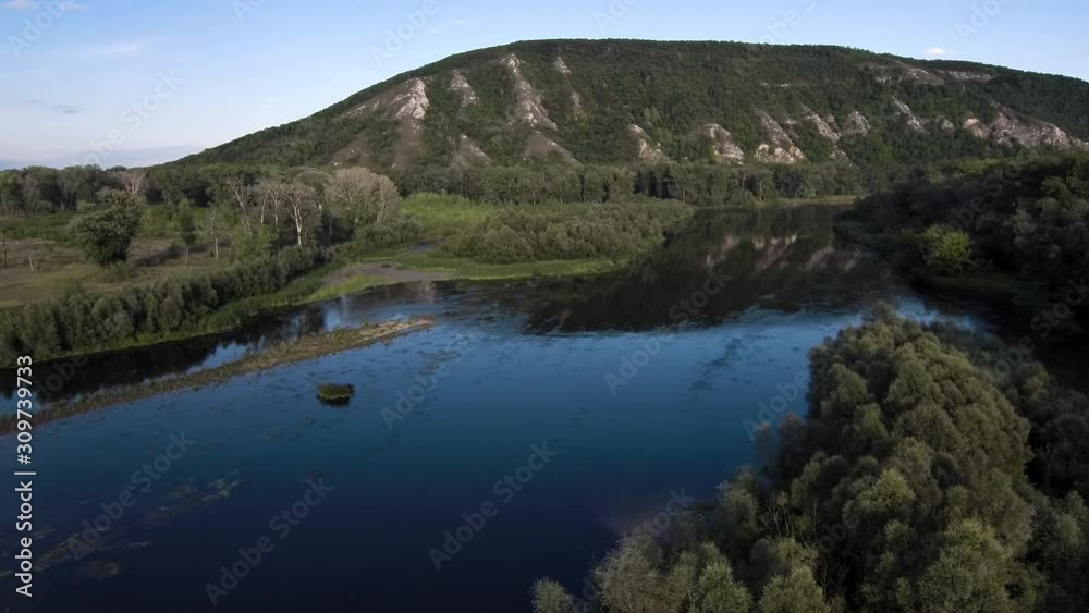 The remain of the reef of the ancient sea, composed of limestone - shikhan Kushtau on a summer day. The main river of Bashkiria - Belaya. Aerial view. The remain of the reef of the ancient sea, composed of limestone - shikhan Kushtau on a summer day. The main river of Bashkiria - Belaya. Aerial view.