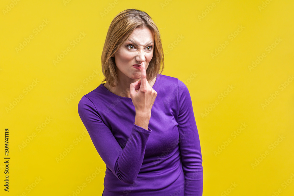 You lie! Portrait of angry young woman in tight purple dress looking aside and pointing at her nose, saying to trickster you are liar, body language. indoor studio shot isolated on yellow background You lie! Portrait of angry young woman in tight purple dress looking aside and pointing at her nose, saying to trickster you are liar, body language. indoor studio shot isolated on yellow background