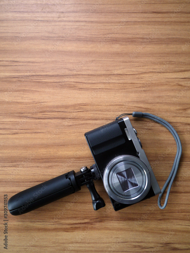 a compact camera with a tripod on a table a compact camera with a tripod on a table