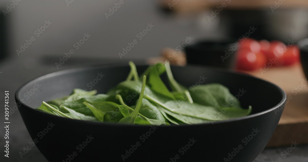 Closeup making salad with spinach, tomatoes and mozzarella Closeup making salad with spinach, tomatoes and mozzarella