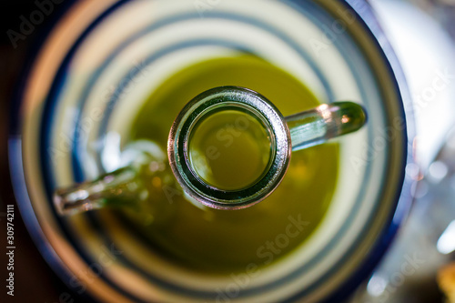 Top view of a cruet full of green extra virgin olive oil.