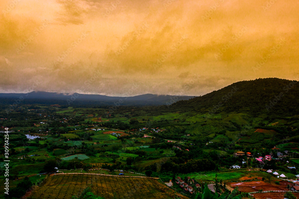 Fototapeta premium The blurred abstract background of a colorful mist fading over the forested mountains, showing the distribution of trees and the integrity of the ecosystem.