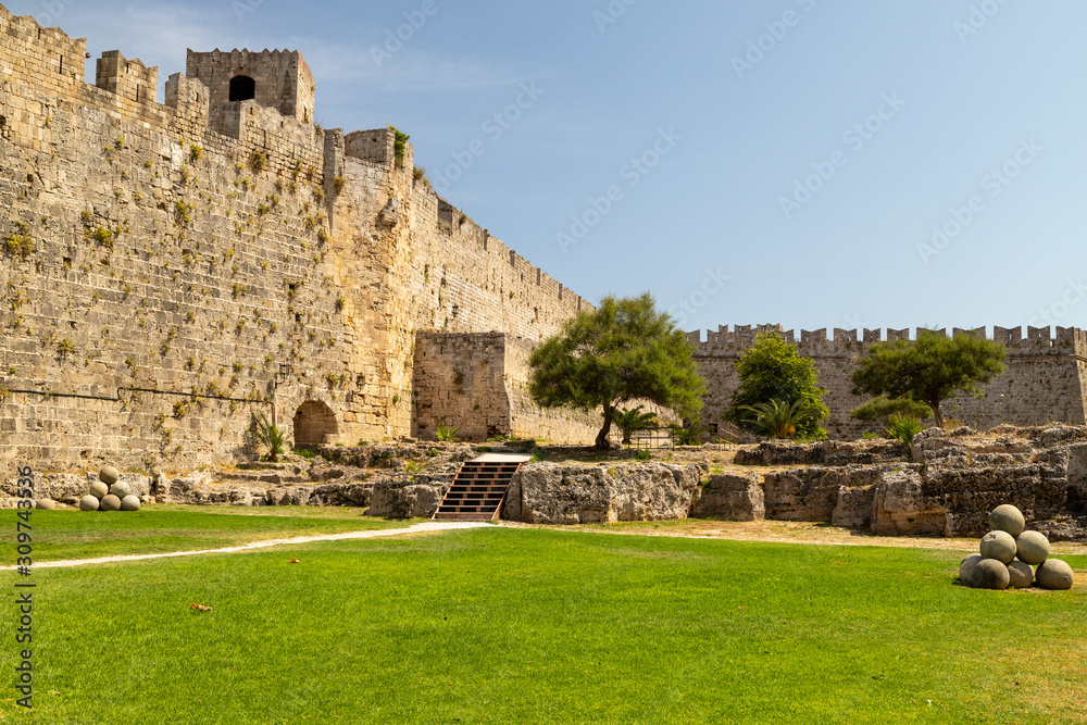 Along the ditch of the antique city wall in the old town of Rhodes city on a sunny day in summer Along the ditch of the antique city wall in the old town of Rhodes city on a sunny day in summer