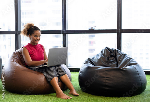 Business team man and woman using digital tablets while relaxing on beanbag
