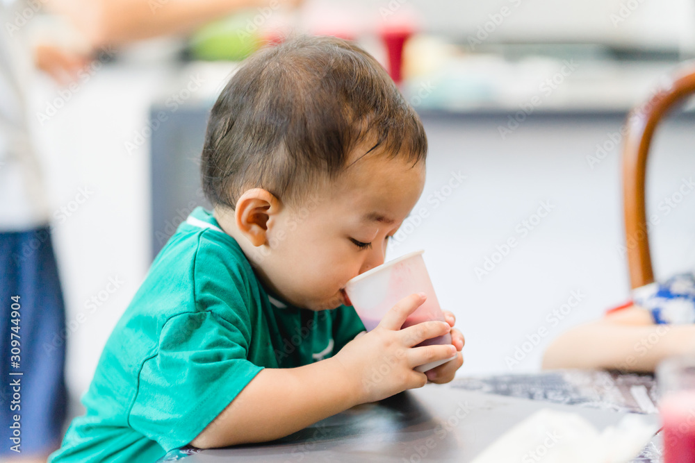 Little asian toddler boy drinking beetroot juice in breakfast time. Little asian toddler boy drinking beetroot juice in breakfast time.