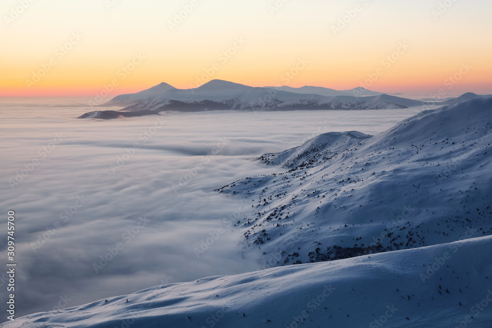Landscape with high mountains, morning fog and beautiful sunrise. Orange sky. Winter scenery. Wallpaper background. Location place Carpathian, Ukraine, Europe.