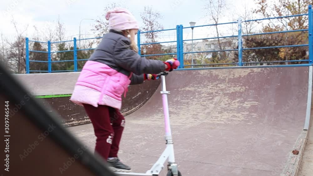 Girl riding a scooter at a skatepark. Girl riding a scooter at a skatepark.
