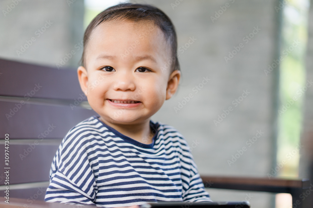 Happy Asian boy child looking cartoon in smart phone.child, technology and internet concept Happy Asian boy child looking cartoon in smart phone.child, technology and internet concept
