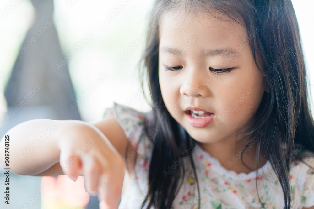 Hungry face and enjoy eating concept.Little asian girl enjoy eating with french fries with cheese on a plate in lunch time at restaurant. Hungry face and enjoy eating concept.Little asian girl enjoy eating with french fries with cheese on a plate in lunch time at restaurant.