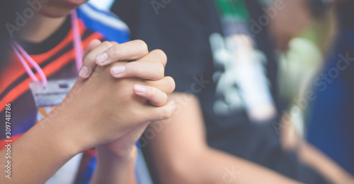 Teenager boy praying at church in the morning.teenager boy hand with faith praying,Hands folded in prayer on a Holy Bible in church concept for faith, spirituality and religion