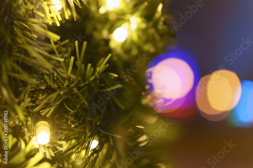 Photography of New Year lights on the fir with defocused background in night. Christmas mood  festive atmosphere. Suitable as template and background for postcards  greeting cards.