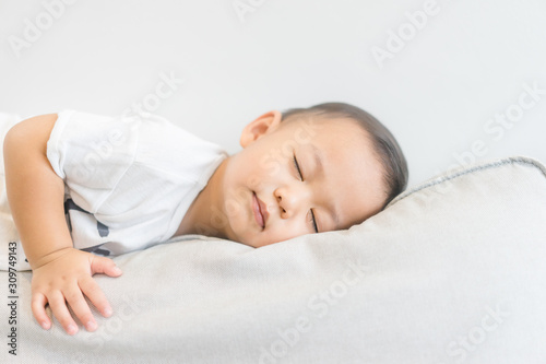 Toddler boy sleeping in sofa and dream.Asian 2 years old baby boy sleep on the sofa in living room.Sleep time,Comfortable, peaceful and growth hormone concept.