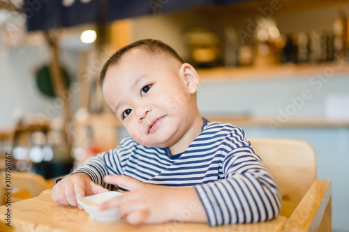 Hungry little asian baby 2 years boy waiting food in lunch time at Japanese restaurant.Enjoy eating and hungry concept.