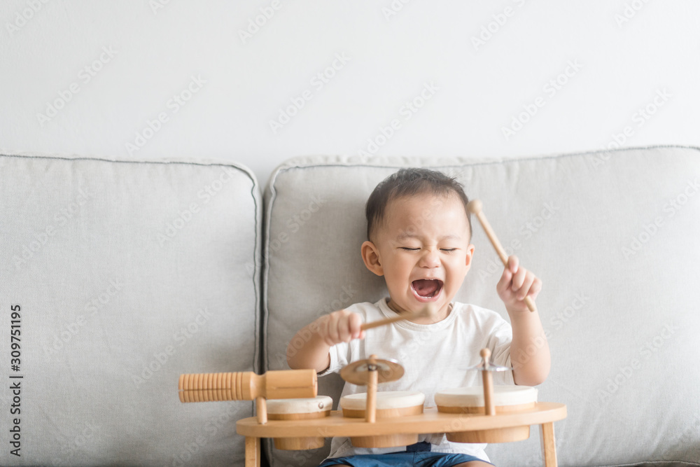 Little baby drummer boy playing and hitting the drum set at home.Asian boy playing and singing happy moment in music lesson time.Child development and Executive function in child concept. Little baby drummer boy playing and hitting the drum set at home.Asian boy playing and singing happy moment in music lesson time.Child development and Executive function in child concept.