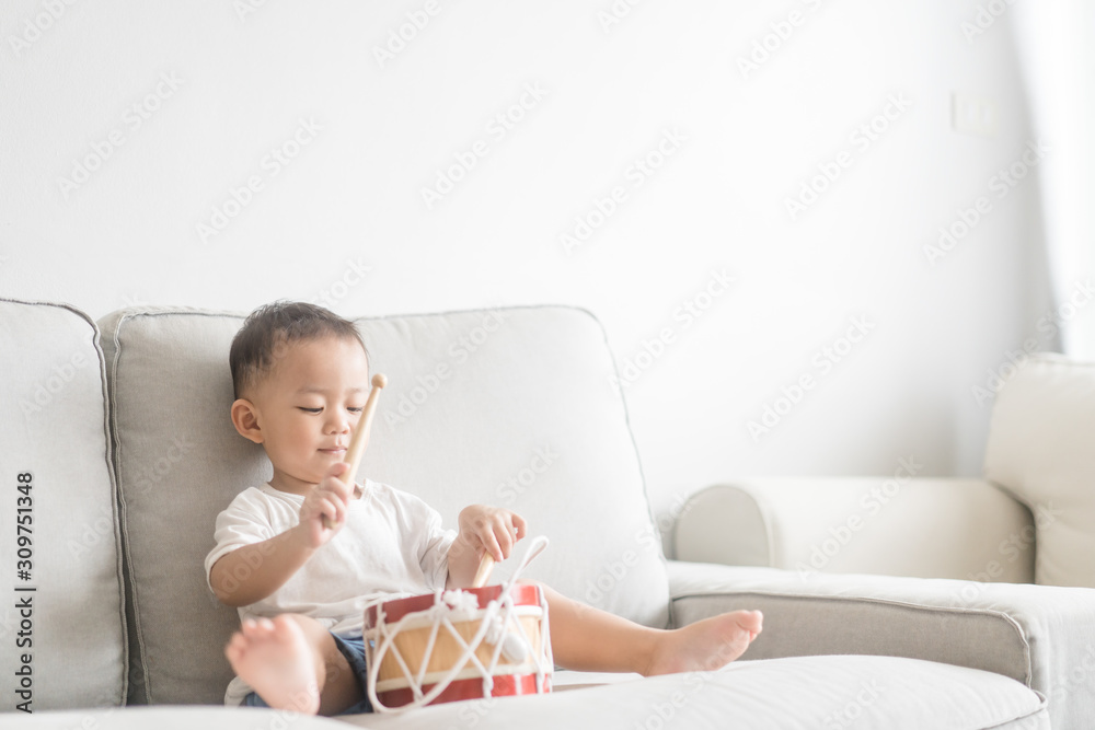 Little baby drummer boy playing and hitting the drum set at home.Asian boy playing and singing happy moment in music lesson time.Child development and Executive function in child concept. Little baby drummer boy playing and hitting the drum set at home.Asian boy playing and singing happy moment in music lesson time.Child development and Executive function in child concept.
