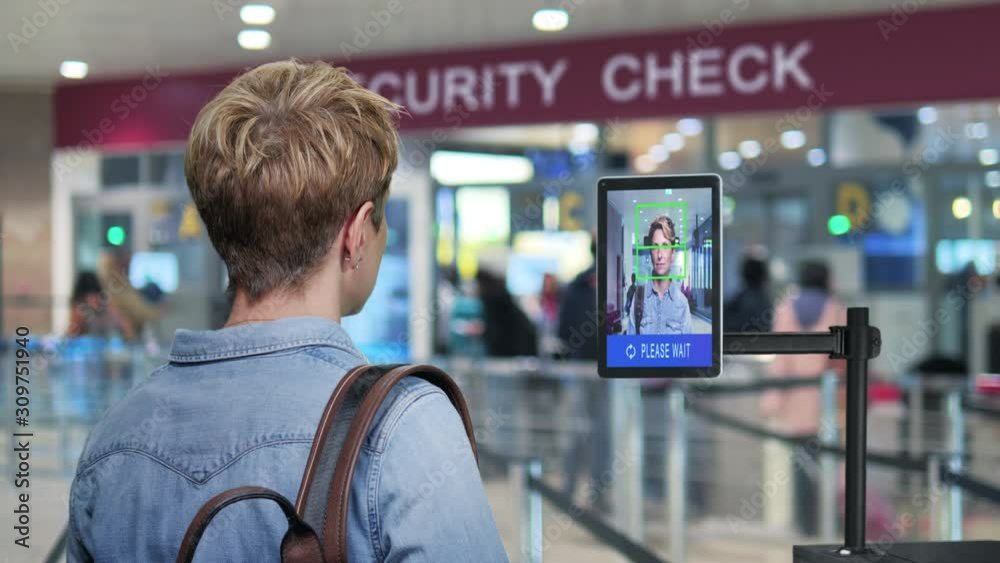 facial recognition system new technology woman goes  through airport security control