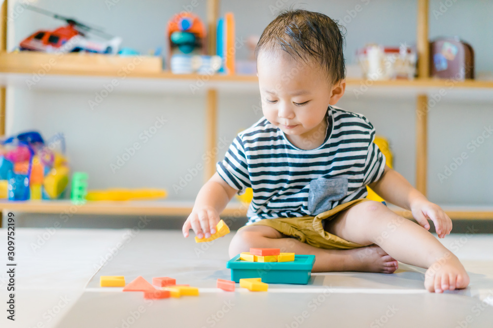 Fototapeta premium 2 years baby boy.Little child boy playing with Shape Creative Puzzle toys block with mother.Kids play with educational toys at home.Day care and Kindergarten school.child development concept.