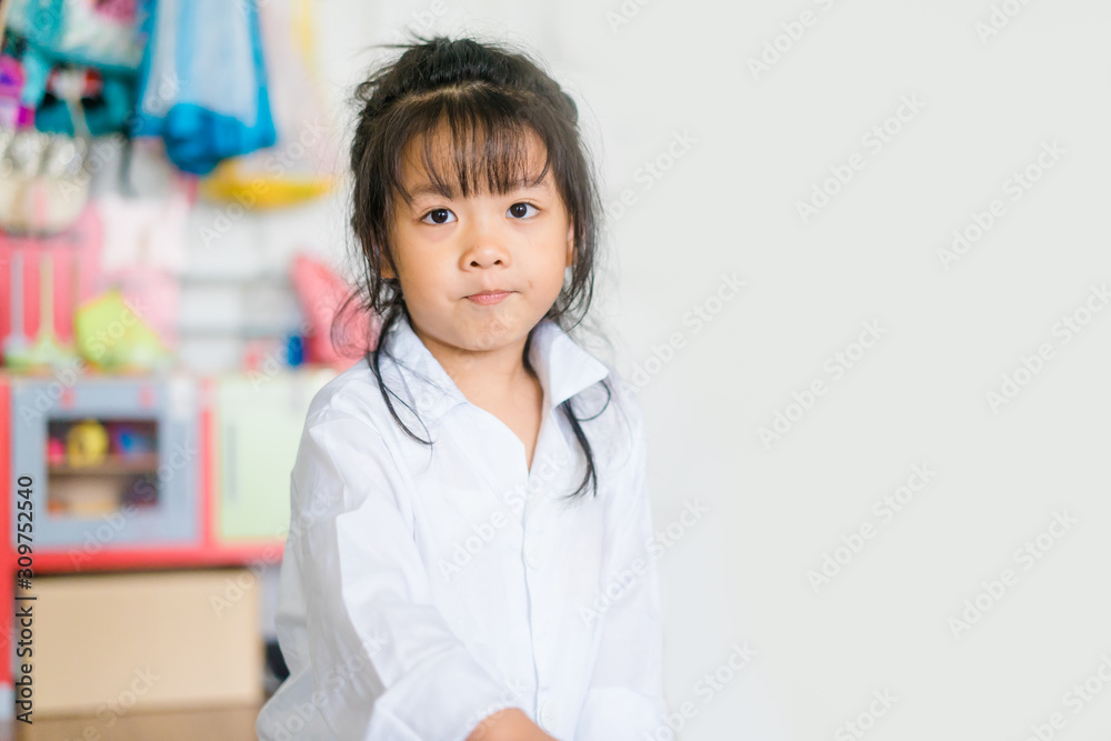 Cute smiling asian girl dressed like a doctor.Smiling little girl playing doctor with Otoscope at home.Doctor, Health care and Occupation Concept. Cute smiling asian girl dressed like a doctor.Smiling little girl playing doctor with Otoscope at home.Doctor, Health care and Occupation Concept.