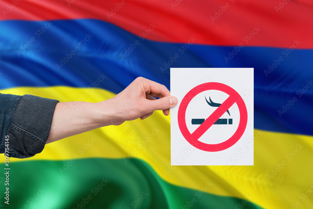 Mauritius health concept. Hand holding paper with no smoking sign over