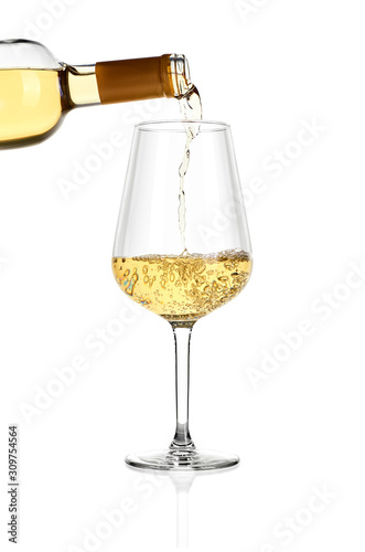 Glass of white wine isolated on white background. From above in glass is poured wine from the bottle.