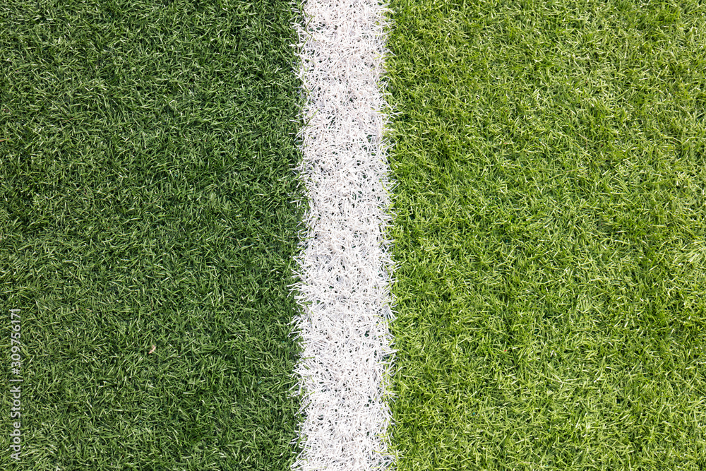 Fototapeta premium White stripe on the green soccer field from top view