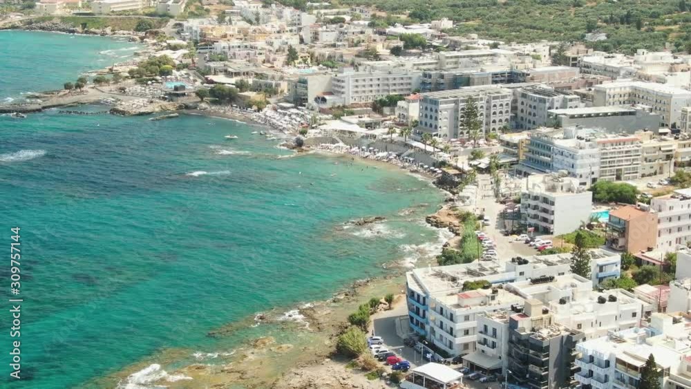 Fly Away From Hersonissos, Aerial View On Blue Sea, Boats And Town Houses Fly Away From Hersonissos, Aerial View On Blue Sea, Boats And Town Houses