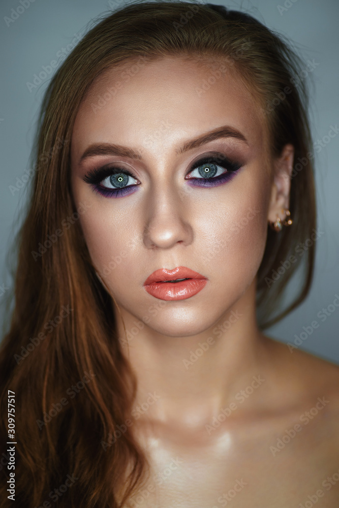 Portrait of a young woman with beautiful evening make-up on a dark background Portrait of a young woman with beautiful evening make-up on a dark background