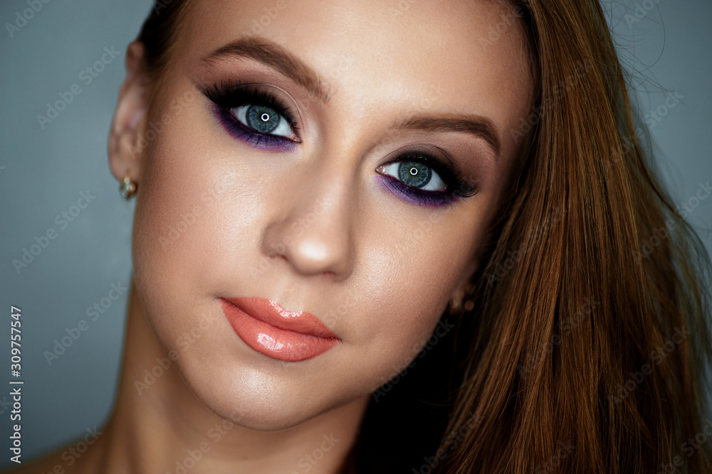 Portrait of a young woman with beautiful evening make-up on a dark background Portrait of a young woman with beautiful evening make-up on a dark background