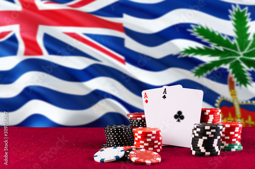 British Indian Ocean Territory casino theme. Aces in poker game, cards and chips on red table with national flag background. Gambling and betting. photo