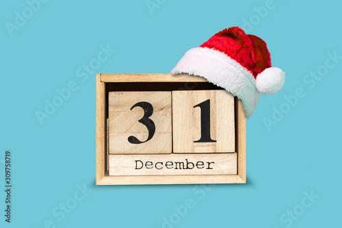 31. December. Calendar of wooden blocks and Santa hat on a blue background. Isolated. New year background.