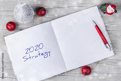 2020. Srategy. Concept of ideas and goals for the new year. Notepad with festive decor on a wooden table. Copy space. Business. Strategy. photo