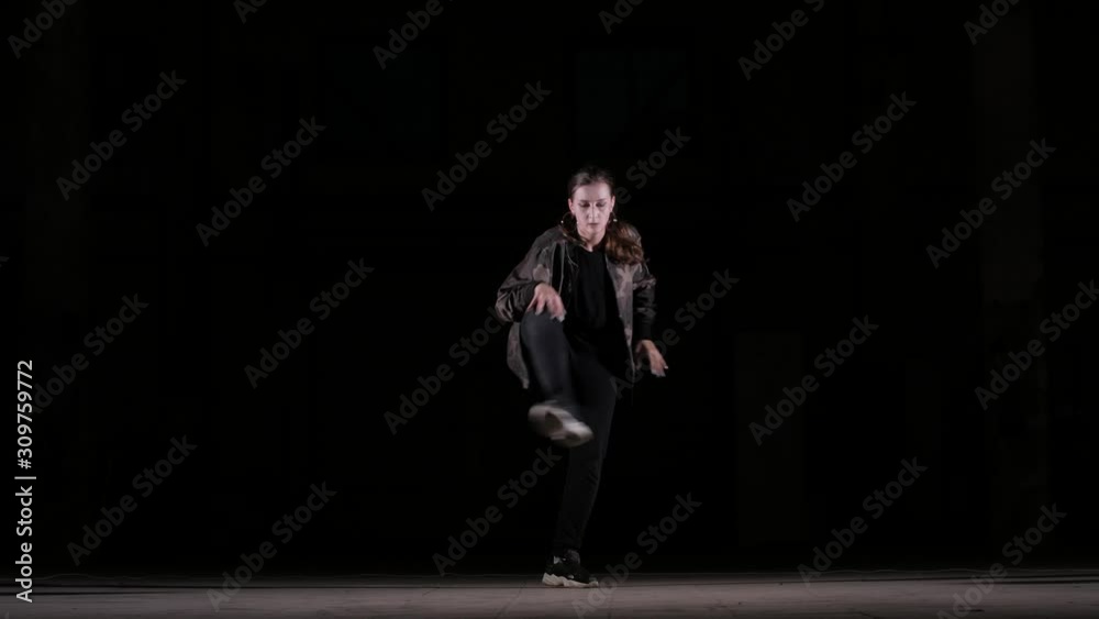 Young beautiful girl dancing hip hop, street dancing in the studio on black background, isolated Young beautiful girl dancing hip hop, street dancing in the studio on black background, isolated