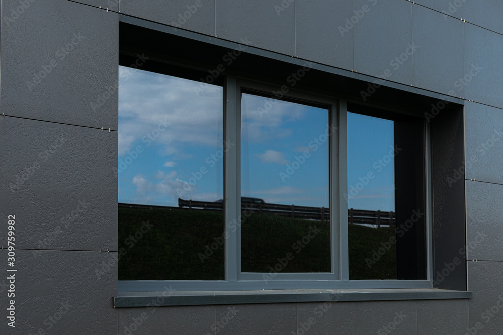Black wall and big windows of tall building with sky reflection Black wall and big windows of tall building with sky reflection