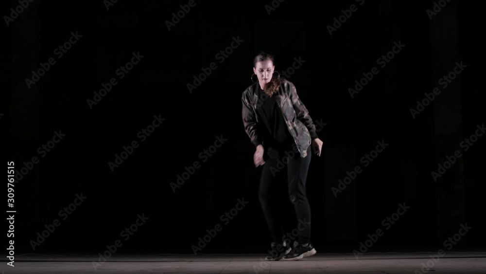 Young beautiful girl dancing hip hop, street dancing in the studio on black background, isolated Young beautiful girl dancing hip hop, street dancing in the studio on black background, isolated