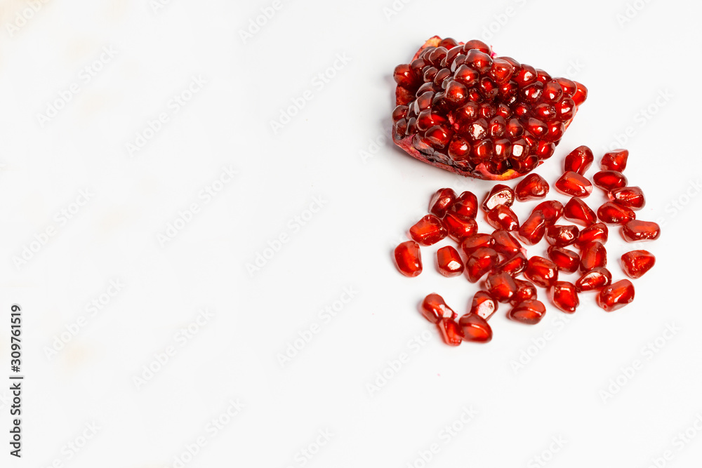 Spoon with ripe pomegranate seeds on a white isolated background. Spoon with ripe pomegranate seeds on a white isolated background.