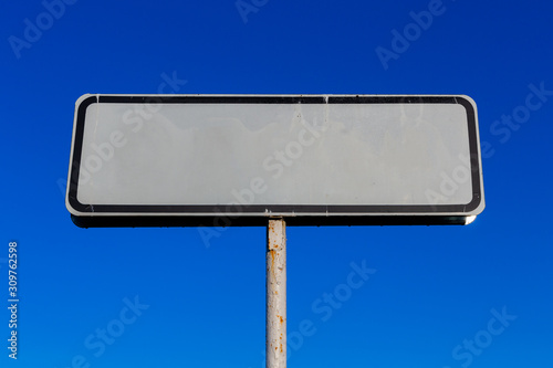 a small white road sign mockup on blue sky background photo