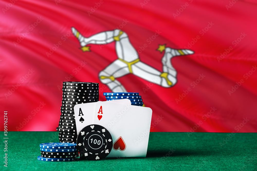 Isle Of Man casino theme. Two ace in poker game, cards and black chips on green table with national flag background. Gambling and betting.
