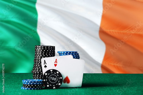 Ireland casino theme. Two ace in poker game, cards and black chips on green table with national flag background. Gambling and betting. photo