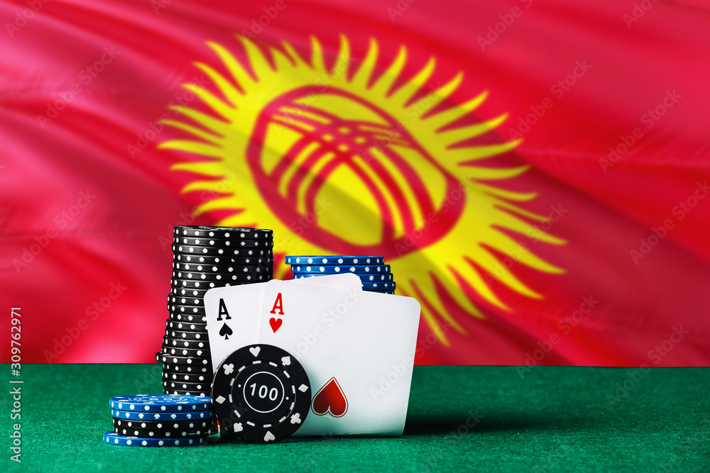 Kyrgyzstan casino theme. Two ace in poker game, cards and black chips on green table with national flag background. Gambling and betting.