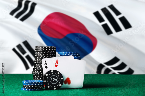 South Korea casino theme. Two ace in poker game, cards and black chips on green table with national flag background. Gambling and betting.