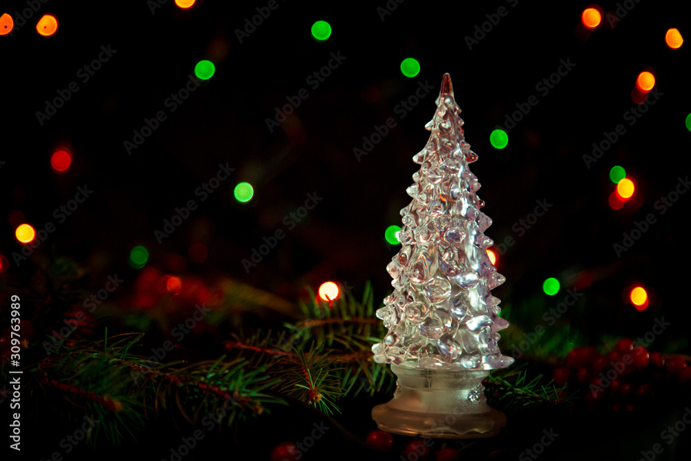 Christmas toys, with green Christmas tree on dark background with lights