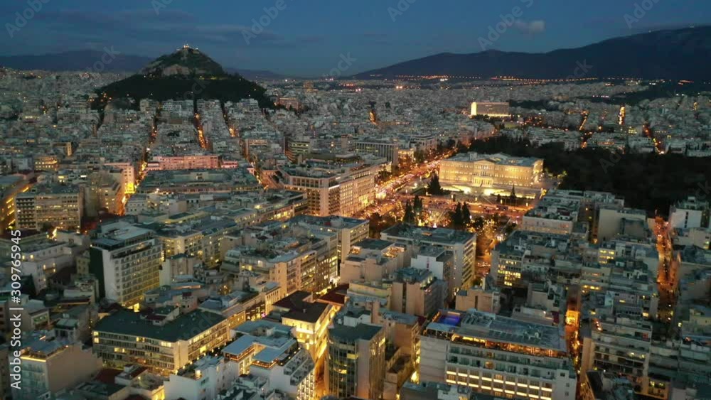 Aerial drone video of illuminated festive Syntagma square featuring Greek Parliament and Christmas tree, Athens centre, Attica, Greece